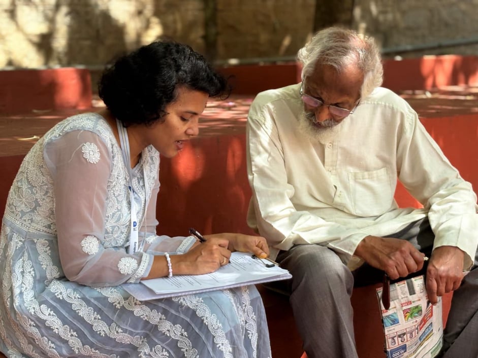 A DIA staff screening an elderly man